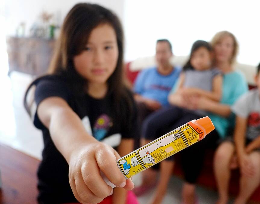 Lillian holds an epi-pen used to treat anaphylaxis