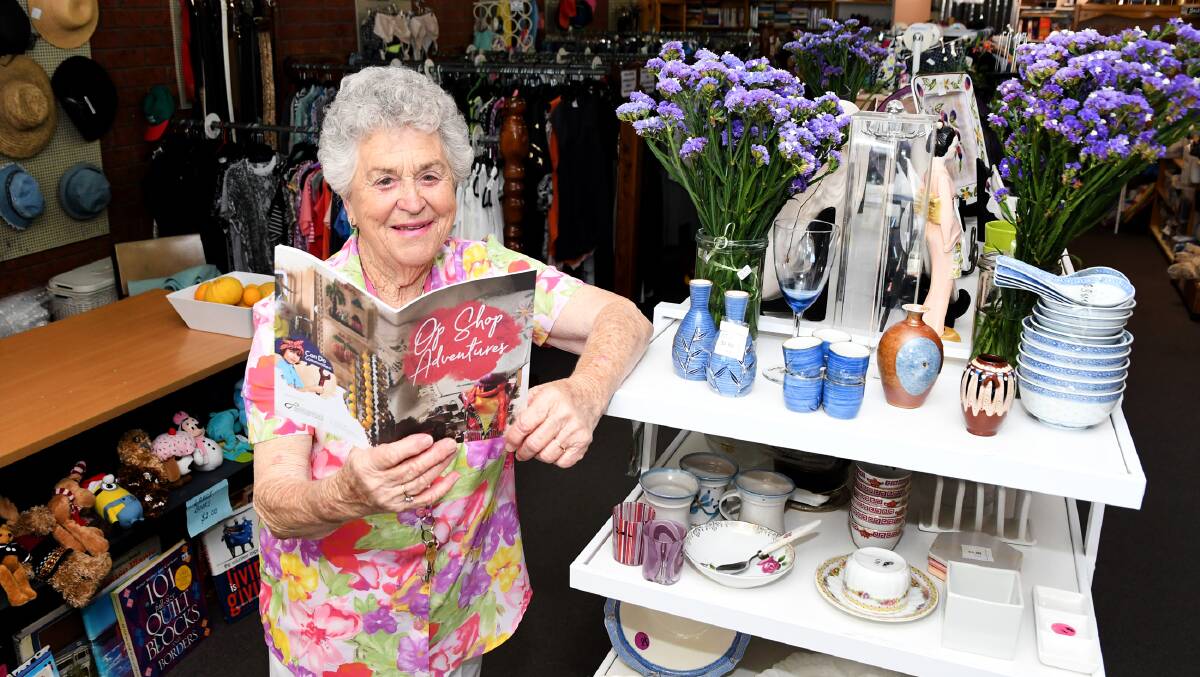 TREASURES: Horsham's Wimmera Base Hospital Ladies Auxiliary Op Shop volunteer Beryl Kemp with a copy of the Op Shop Adventures book. Picture: SAMANTHA CAMARRI