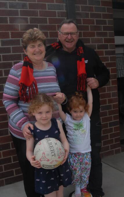 Cap: Tony and Jenny Kirchner with grandchildren Kensi, 4, and Marney, 2, are ready to celebrate a weekend of netball and football finals.