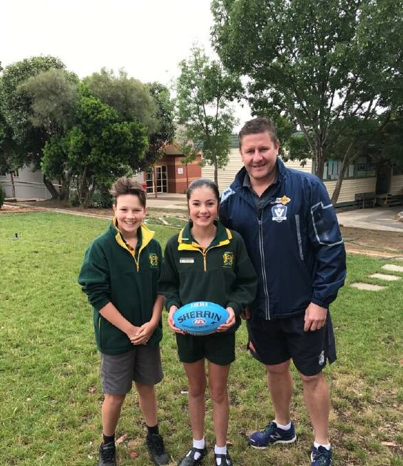 DONATION:  AFL Wimmera-Mallee football development manager Jason Muldoon presents new footballs to Ararat West Primary School. Picture: CONTRIBUTED
