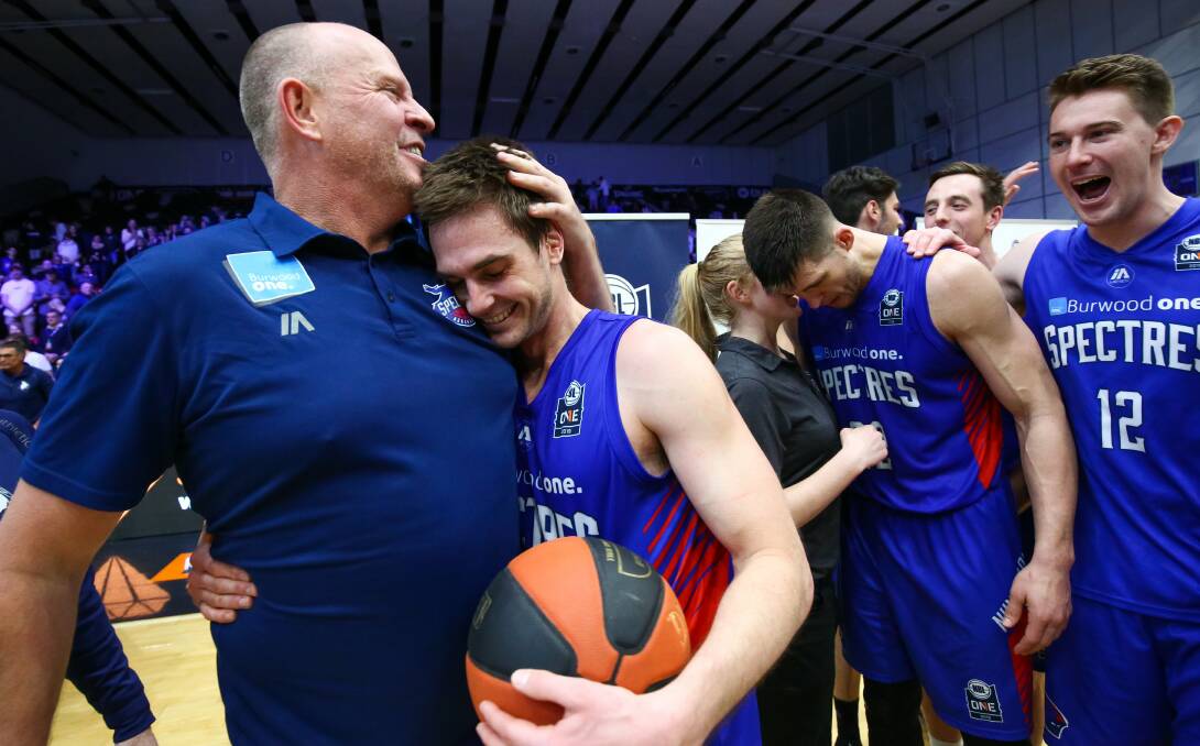 CHAMPIONS: Shane McDonald embraces his coach and celebrates with the game ball in hand. Picture: IAN KNIGHT