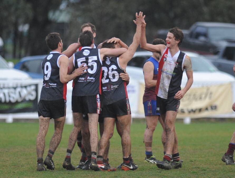 The Horsham Saints celebrate on the final siren, while Nick Caris (right) gets a big high five for his match-winning performance. Caris booted three goals for the contest, including two in the final 10 minutes to propel his side to victory. Pictures: RICHARD CRABTREE