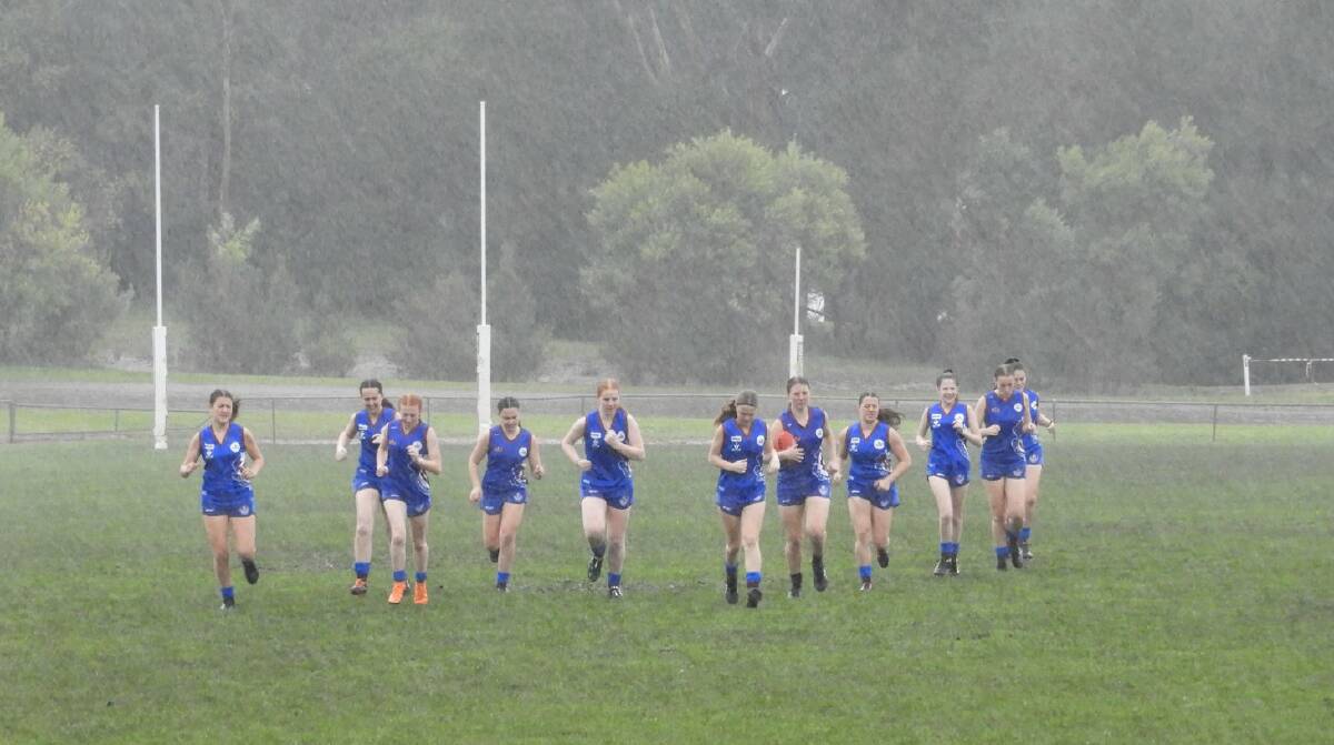 The Demons try to warm up in the pouring rain on Sunday. Picture: DONNA ELLIS