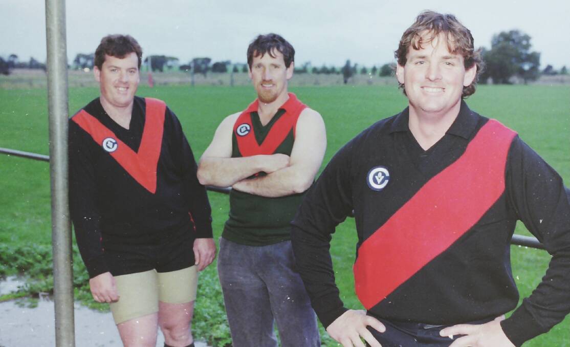 OLD AND NEW: Brett Freeman, Wayne McDonald and Mark Hoffman show off the three jerseys in 1997 - the Quantong jumper, the green and red Noradjuha jumper and the new red-sash jumper worn after the merge.