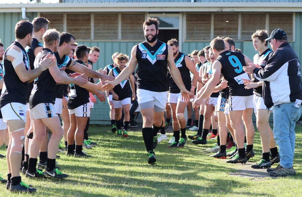 Ruckman Matt Healy leads Swifts out of the rooms, past supportive reserves players. Picture: TRISH RALPH
