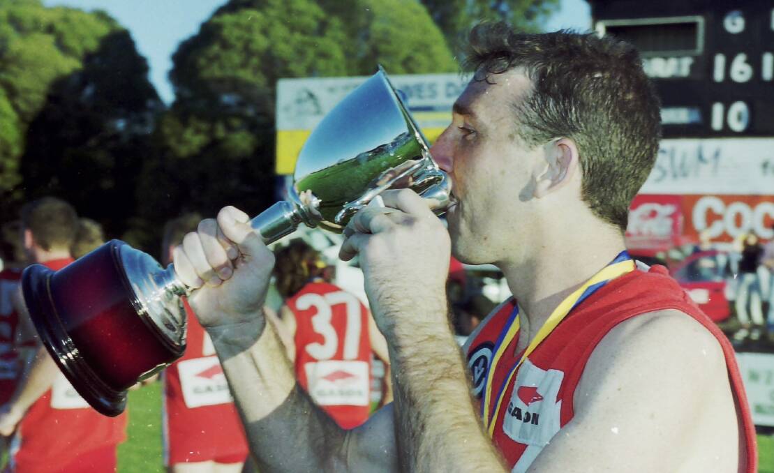 Shaun Allen drinks from the premiership cup.