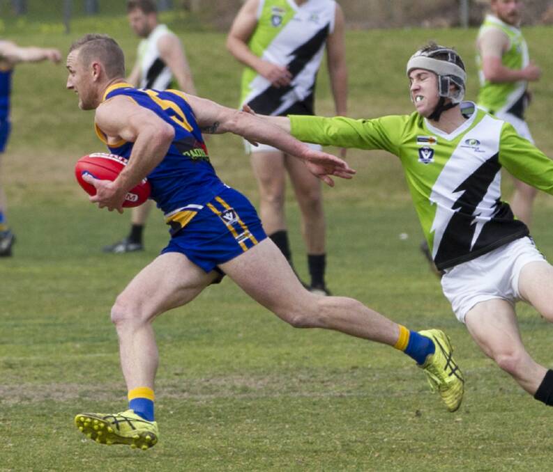 Anson brushes aside a would-be tackler while playing with Natimuk United in the Horsham District league. Picture: PETER PICKERING