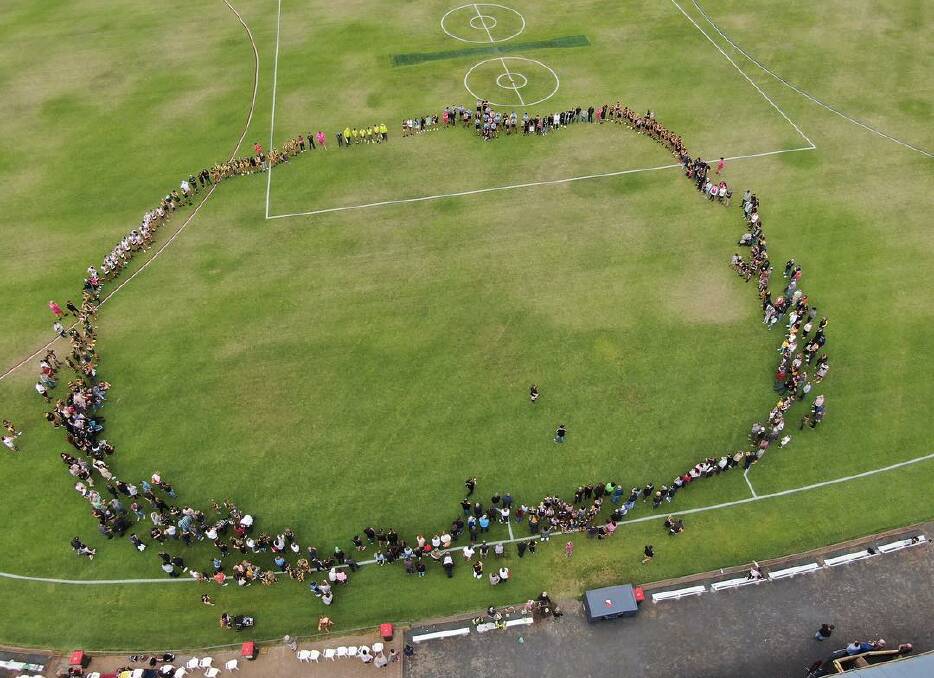 TOGETHER: Players, volunteers and spectators unite to form a circle at Davis Park. Picture: CONTRIBUTED