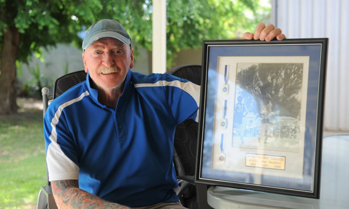MEMORABLE ACHIEVEMENT: Brian 'Cobber' Cassidy holding a frame featuring his three Kowree-Naracoorte Football League best and fairest awards from the 1980s. He won the award in '83, '85 and '88. Picture: SEAN WALES