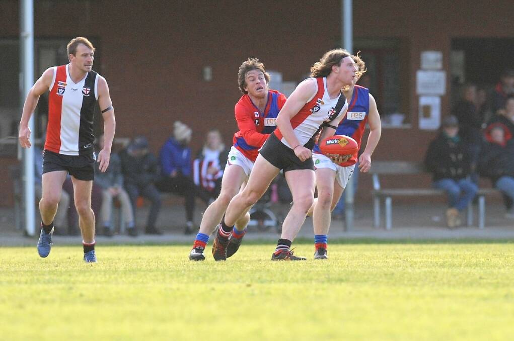 Edenhope-Apsley's Lachlan Middleton breaks a tackle from Kalkee co-coach Hamish Exell when the two teams met earlier in the season. 
