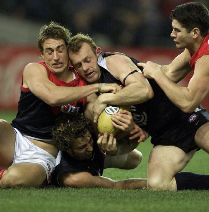 Round 15.Carlton v Melbourne.Colonial Stadium. Melbourne's Clint Bizzell clutches the ball with Carlton's Adrian Hickmott and Andrew Merrington. Picture: Sebastian Costanzo