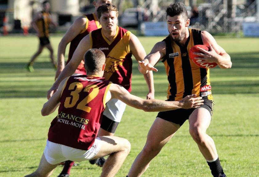 Tim McIntyre fends off a Border Districts opponent playing for Mundulla this season. Picture: BORDER CHRONICLE