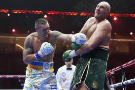 Oleksandr Usyk (l) rattles Tyson Fury on his way to becoming undisputed heavyweight world champion. (AP PHOTO)