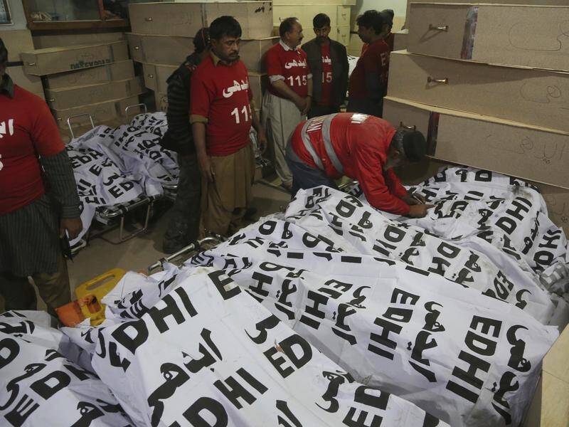 Volunteers arrange bodies of passengers killed in an bus accident, in Karachi, Pakistan.