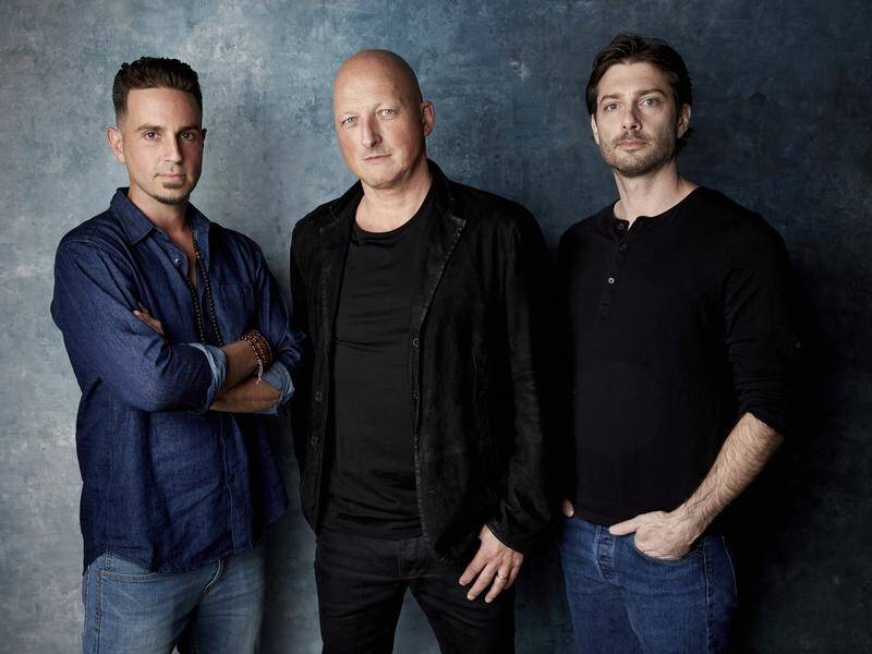 Wade Robson director Dan Reed and James Safechuck pose appear in the Leaving Neverland documentary.