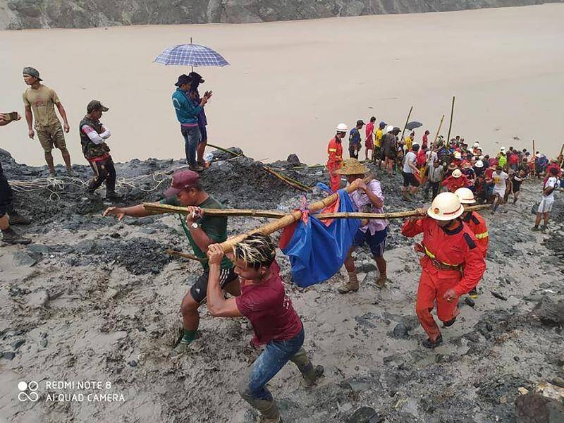 Rescuers carry the recovered body of a landslide victim at a jade mine in northern Myanmar.