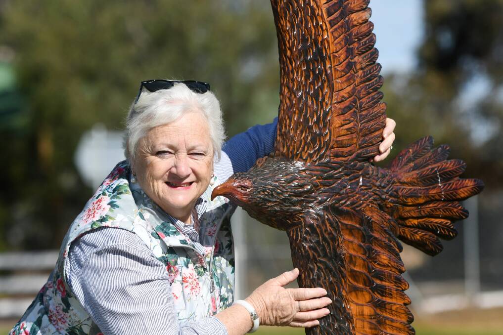 ART: Rupanyup's Carmel Healy with the town's latest flying eagle chainsaw artwork along Cromie Street. Picture: SAMANTHA CAMARRI
