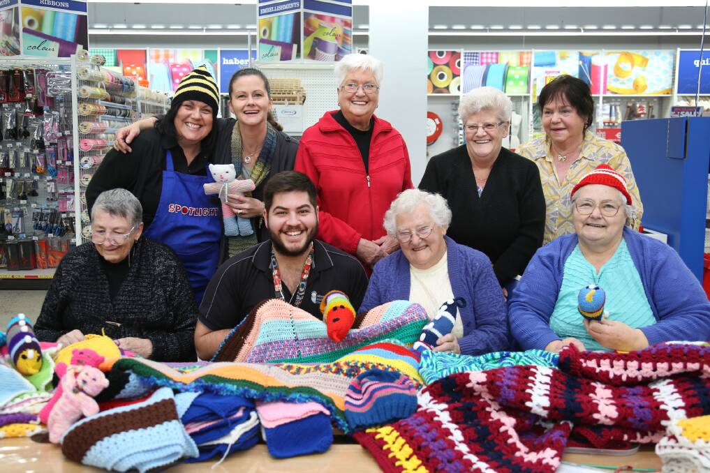 KNITTING FOR A CAUSE: Mary Starick, Val Krause, Mary Birch, Nicole Beavis, Peta Atkins, Roma Simpson, Helen Perry and Di Kowaczyk donate blankets from the knitting group to Loucas Vettos of Wimmera Uniting Care. Picture: THEA PETRASS