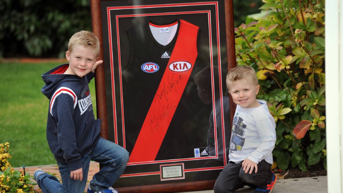 READY TO GO: Watson brothers Lachlan, 6, and Hamish, 3, support their grandparents' fundraiser. Judy and Trevor Howie's team MASH is auctioning the signed Essendon guernsey as part of a Relay for Life fundraiser. The boys are unrelated to father and son Essendon champions Tim and Jobe Watson. Picture: PAUL CARRACHER
