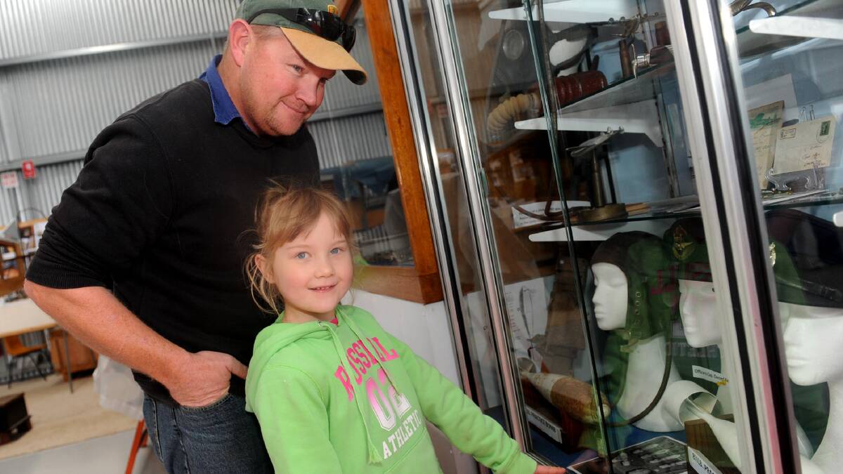 BACK IN TIME: Andrew Trenery and his daughter Alisa, 6, of Nhill, check out some of the memorabilia on display at Nhill Aviation Heritage Centre during the Studebaker
Midway Rally at the weekend. Picture: SAMANTHA CAMARRI