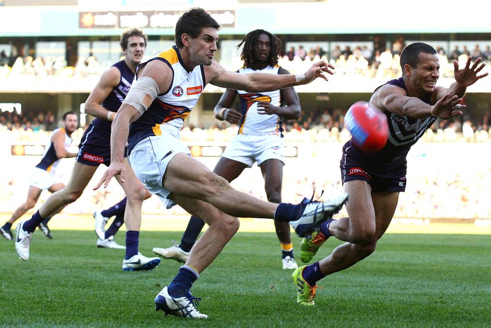 MILESTONE MATCH: West Coast Eagles midfielder Matt Rosa gets a kick away despite an attempted smother from Fremantle opponent Danyle Pearce in his 150th AFL game on Saturday. Picture: GETTY IMAGES