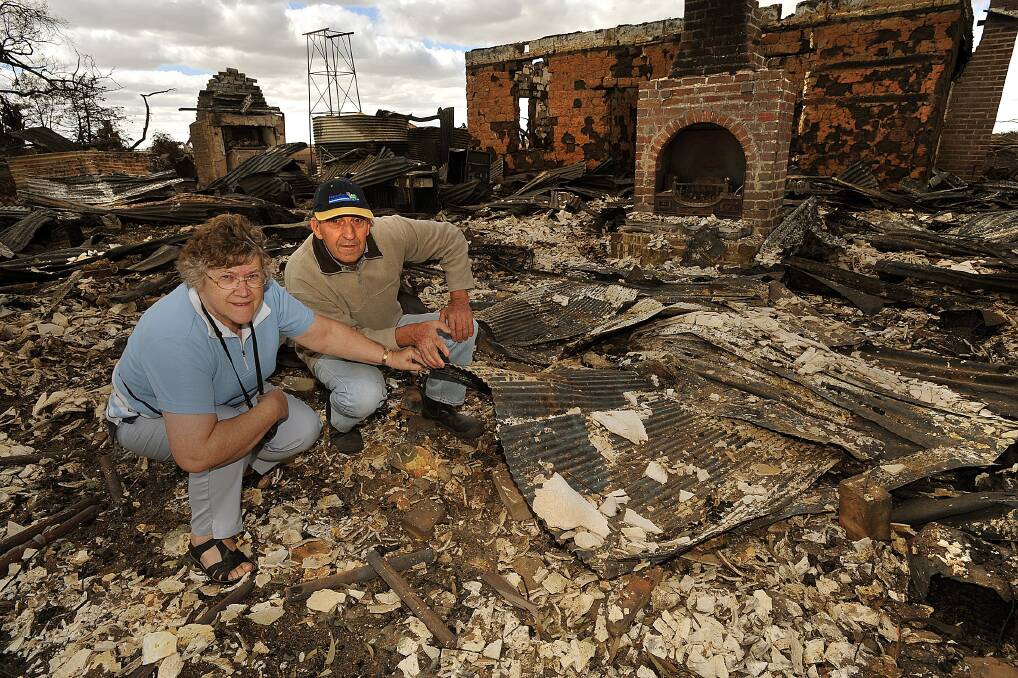 BLACK SATURDAY: Cynthia and Alan Peterson with remains of their old farmhouse lost during the fire.