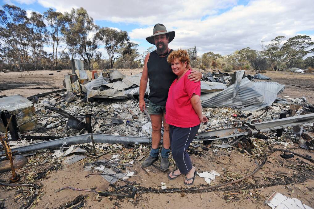 BLACK SATURDAY: Mark and Karen Smith with the remains of their home. Picture: KATE HEALY