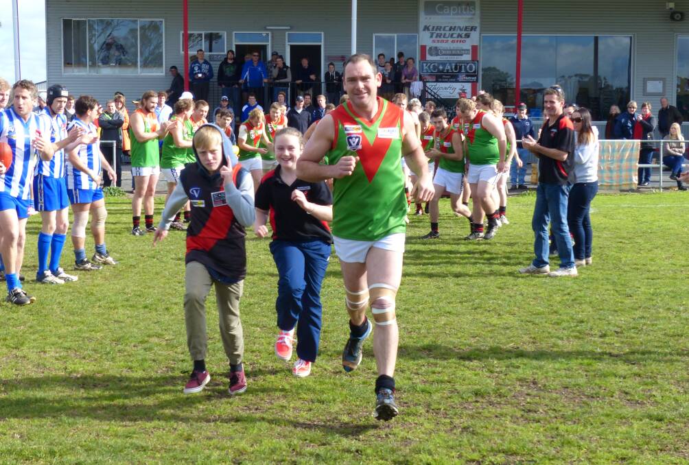 SPECIAL MOMENT: Jardy Walter – pictured with children Jye, left, and Jenna – runs onto Quantong Recreation Reserve for his 350th game at the weekend.