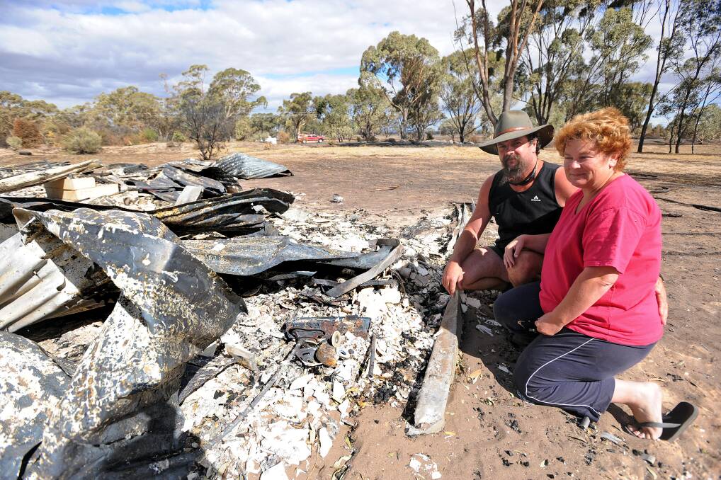BLACK SATURDAY: Mark and Karen Smith with the remains of their home. Picture: KATE HEALY