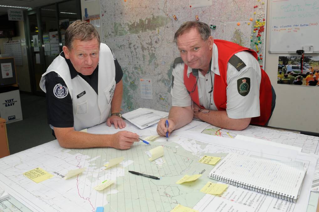 BEHIND THE SCENES: Incident controller Dale Russell and operations manager Mal Gibson look over a map of the Grampians fires at the incident control centre. Picture: SAMANTHA CAMARRI