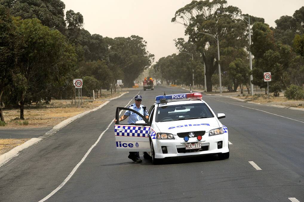 ON DUTY: Horsham police block Golf Course Road in Horsham at the direction of the incident control room during the Remlaw fire on February 7, 2009. Picture: PAUL CARRACHER