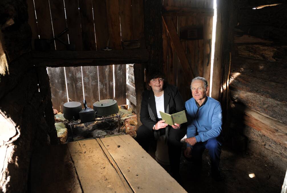 REVISITING HISTORY: Ros Ryan and Robert Isaacson inside the Jane Duff replica cottage at the Duffholme Museum, Mitre. Ms Ryan is holding a primary school reader with the story of Lost In The Bush in it. Picture: PAUL CARRACHER