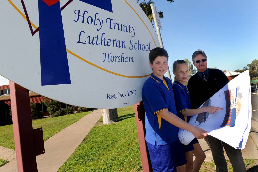 STEP FORWARD: Holy Trinity Lutheran School grade six students Bailey Driller, 11, and Rachel Maroske, 12, and business manager Garry Wallace celebrate the school receiving money for their secondary school expansion. Picture: SAMANTHA CAMARRI