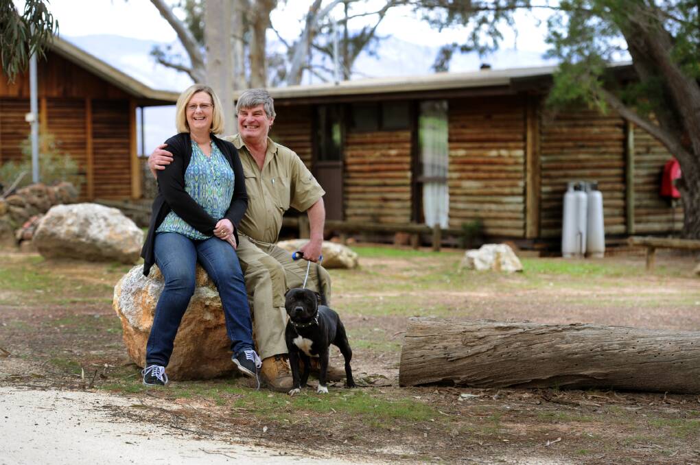 HAPPY AGAIN: Janet and Garry McLachlan with dog George at Happy Wanderer Holiday Resort, which has re-opened after the Grampians bushfire in January. Picture: PAUL CARRACHER