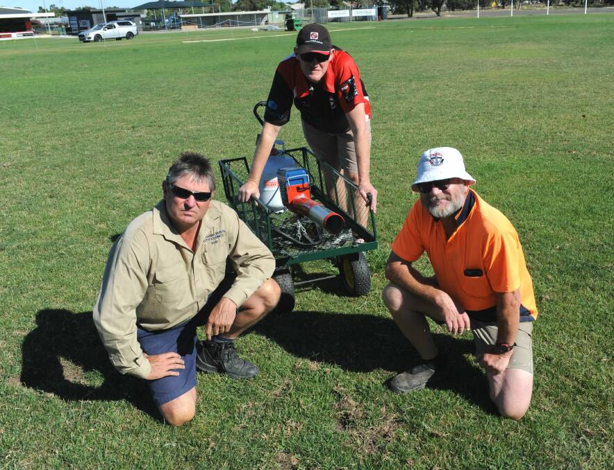 MINEFIELD: Rod Lawson, Glenn Carroll and Tim Lannen inspect Coughlin Park's Oval on Thursday morning with the club's ineffectual scare gun. Picture: STUART McGUCKIN