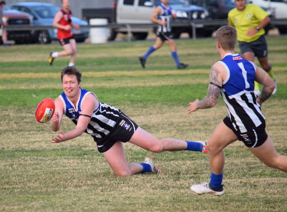 MOVEMENT: Brayden Ison dishes off a handpass while falling during Minyip-Murtoa's round eight win against Stawell. Picture: RILEY KEEL