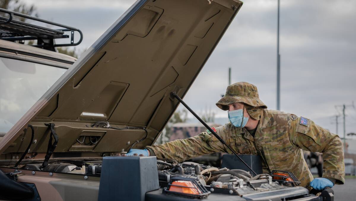 FRONTLINE: Private Gerard Emmett checks a Mercedes G Wagon prior to delivering supplies to ADF personnel on the frontline in Melbourne. Picture: LAC John Solomon