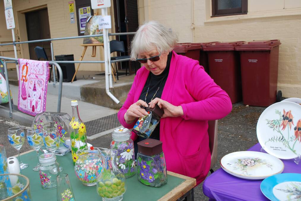 CREATIVE: Marie Anson displaying glass painting goods for sale at the U3A market day.