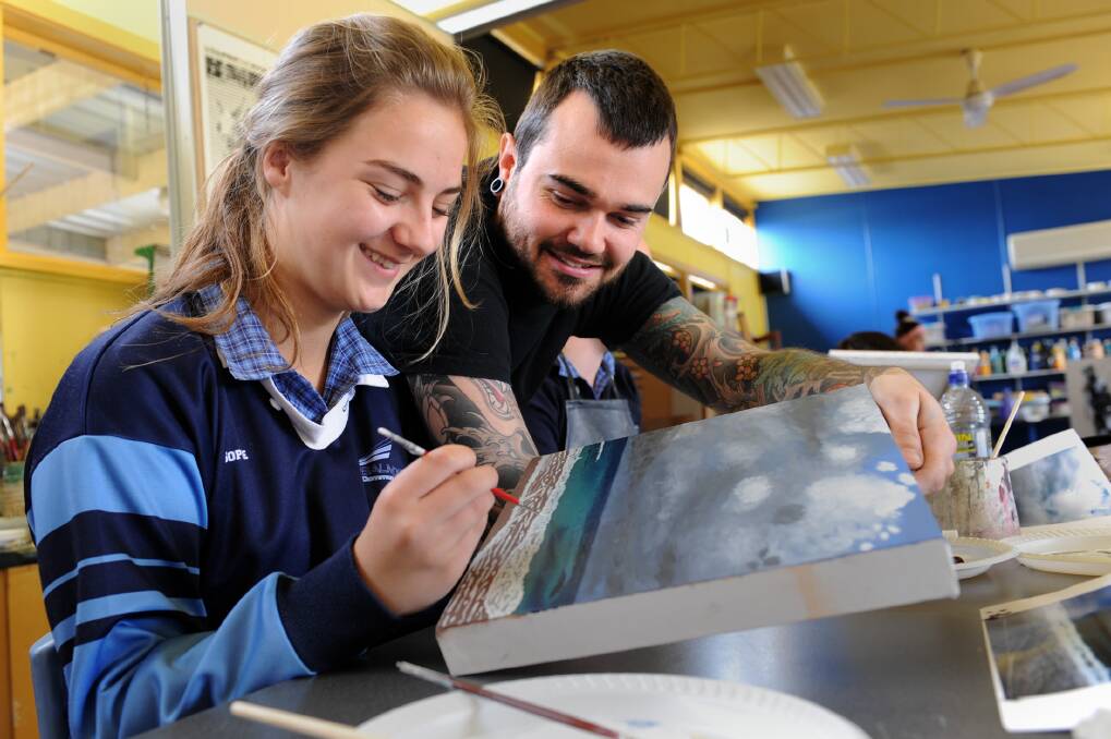 Artist Brett Hayes works with Balmoral College student Sophie Edgerton on a painting. Picture: PAUL CARRACHER