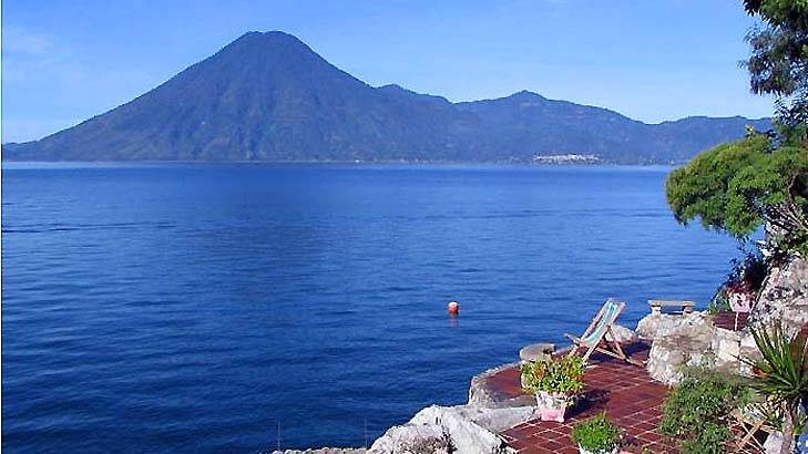 Casa del Mundo is a Spanish-colonial-style house set on the steep shores of Lake Atitlan, with views over the water to three towering volcanoes on the other side.