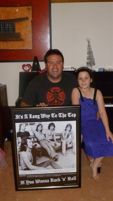VENTURE: Shaun Scully and his daughter Neisha, with one of 500 copies of a picture of AC/DC at Horsham Railway. Mr Scully reproduced the image in partnership with friend and former Rupanyup resident Steven Delrayne. They want to see the picture hanging in Horsham, given its significance. Picture: CONTRIBUTED