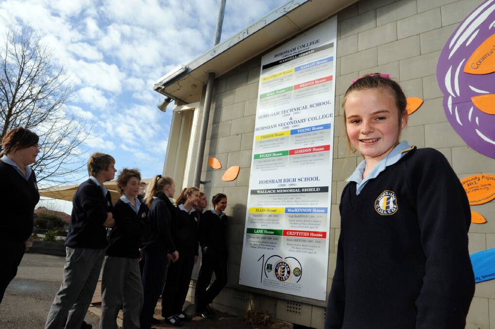 Horsham College student Sam Lawson, front, and fellow students, pictured with one of the new Horsham College signs linking back to the school's history. Picture: PAUL CARRACHER