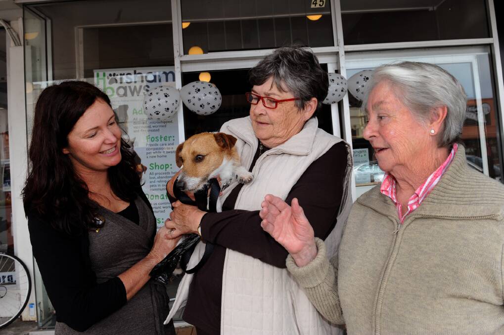Horsham PAWS president Lydia Ward and volunteers Glenda Pizzoni and Marion Sharry, with dog Olly, celebrate day one of the group's new shop. Picture: PAUL CARRACHER