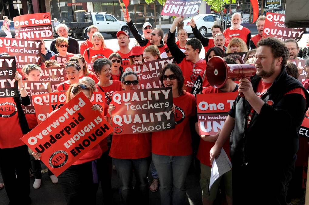 SHOWING THEIR COLOURS: Australian Education Union Victorian branch vice president Justin Mullaly, right, leads a chant outside Member for Lowan Hugh Delahunty's Horsham office yesterday. Teachers dressed in red - the union colour. Picture: PAUL CARRACHER