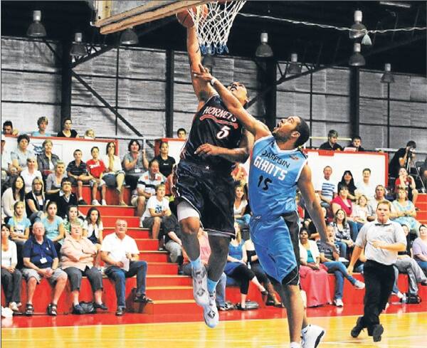 WHAT GOES UP...: Hornets forward Damien Skurrie is fouled heavily by Giants forward Jonathan Hall as he attempts a dunk.
