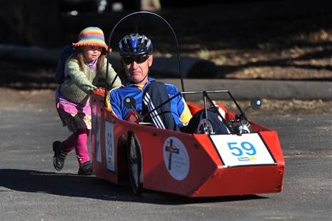 Jeff Gork gets a push from Isabelle Hoskins at Art Is... family fun ride.